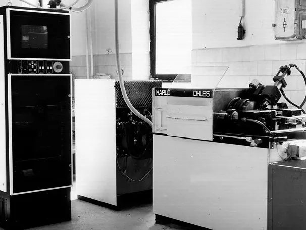 The DHL-65 friction welding machine in the workshop, with the control cabinet beside it, archive photo