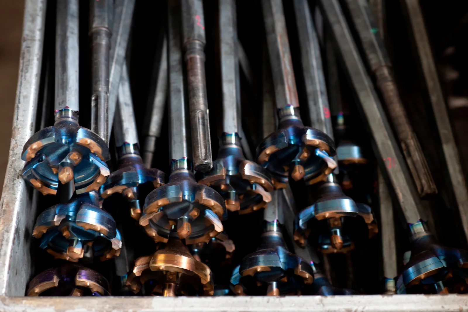 Welded core drills in a crate, the drill heads facing the camera