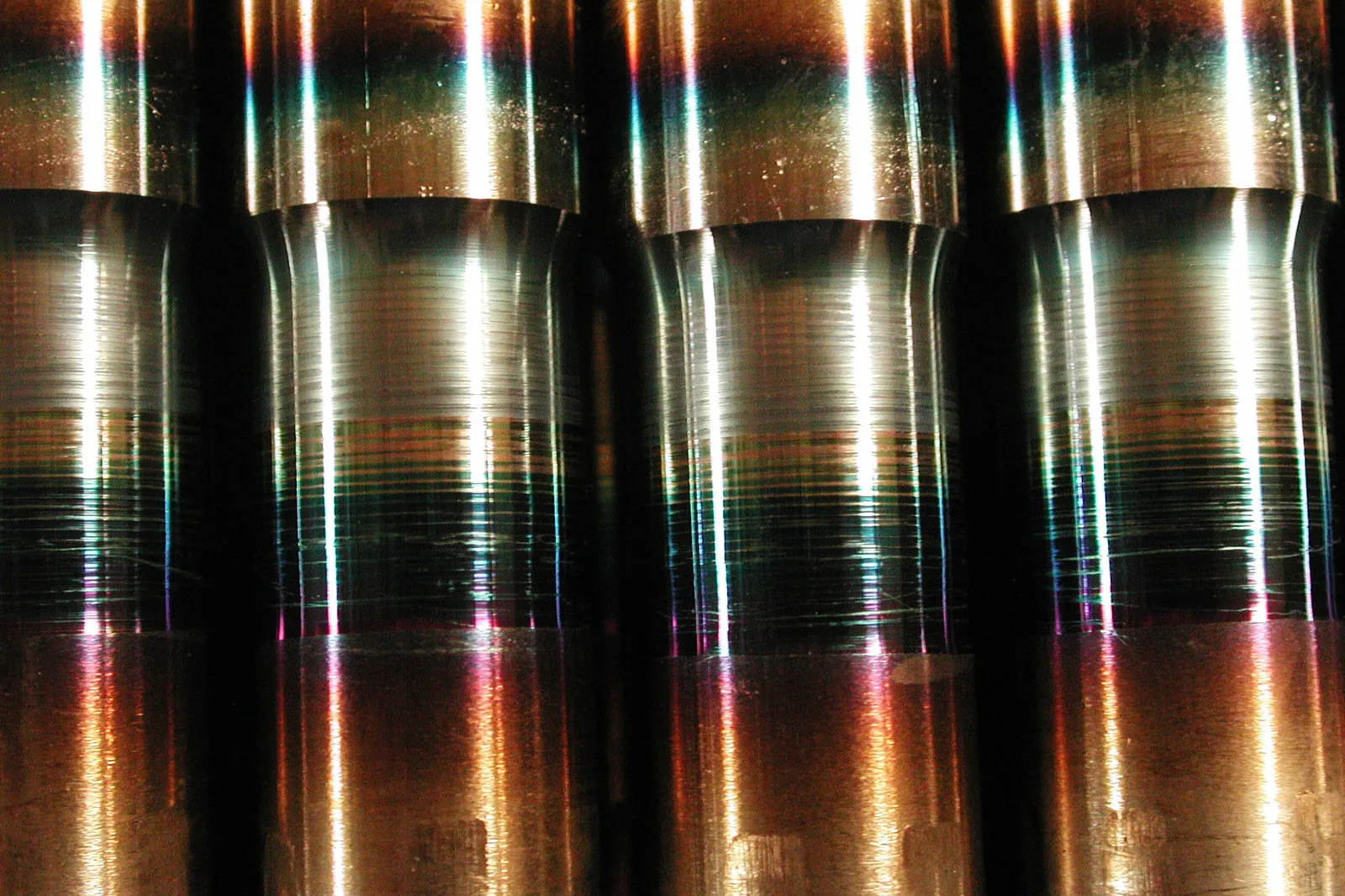 Friction-welded shafts in a row, with the heat-tinted zone at the weld
