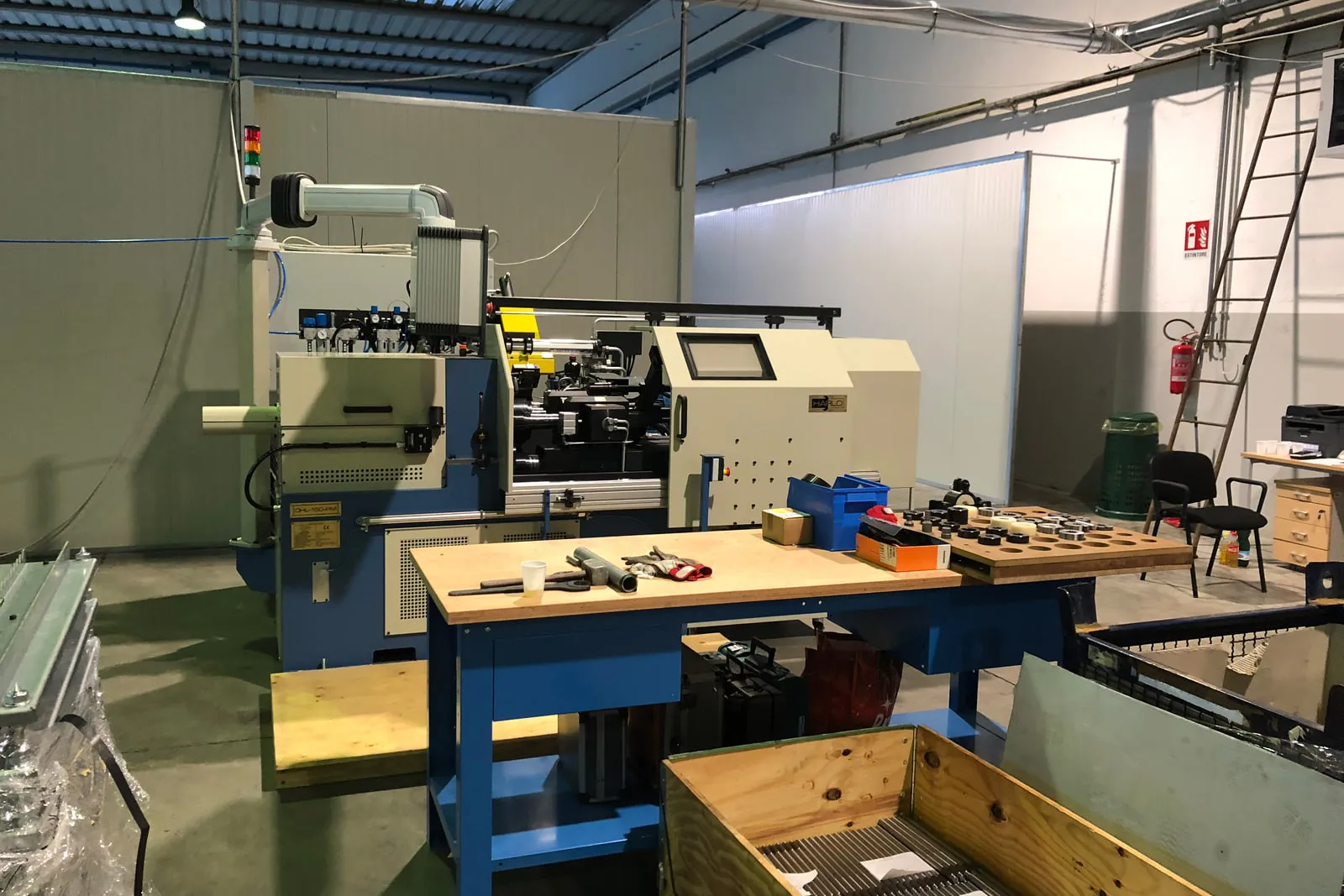 Friction welding machine in the workshop, with a workbench of tools and clamping elements in front of it
