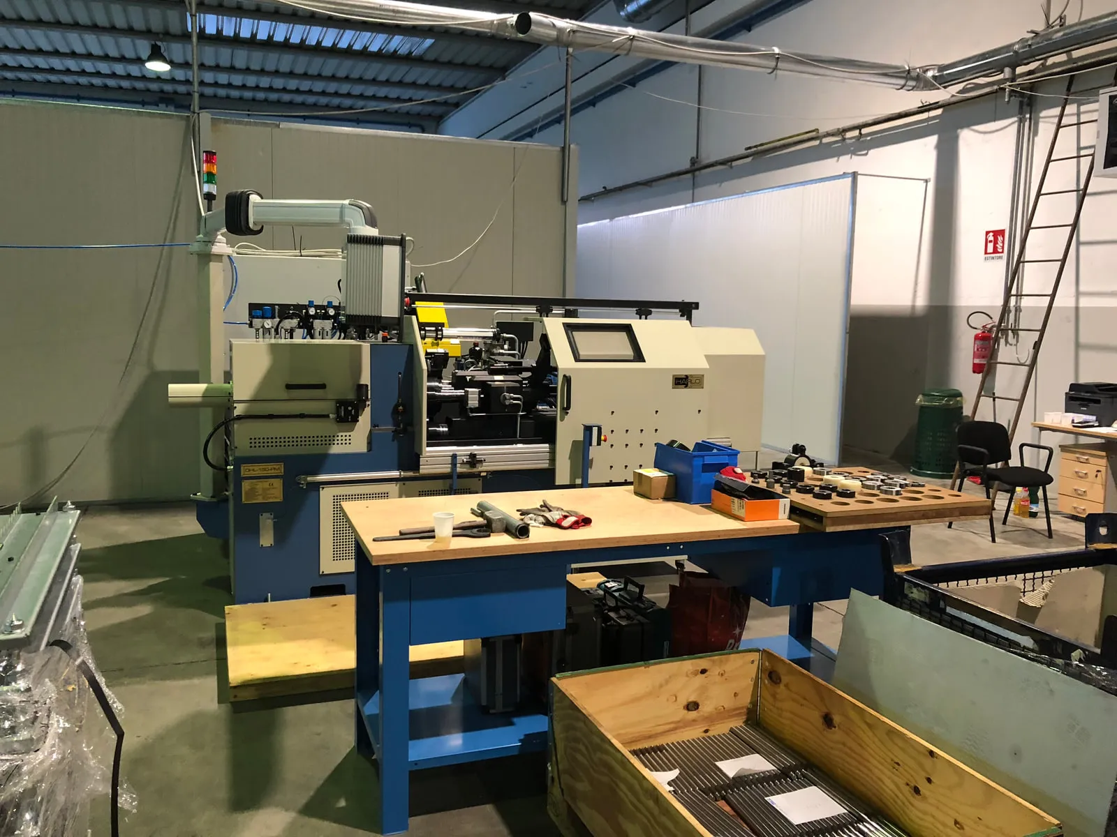 Harlo's workshop today: blue workbenches, machine tools behind them in the hall